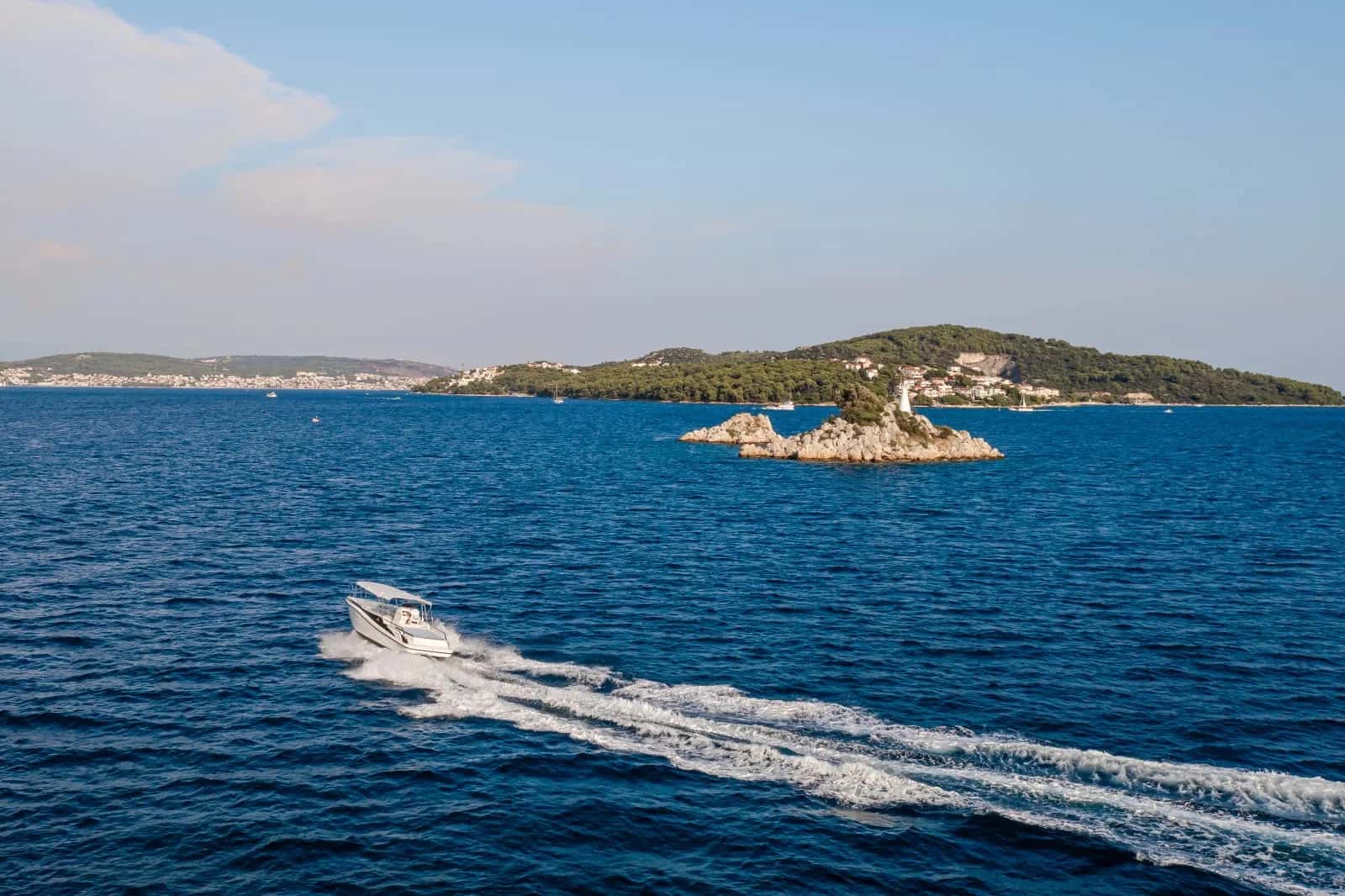 SeaExplore speedboat cruising past a lighthouse islet near Trogir