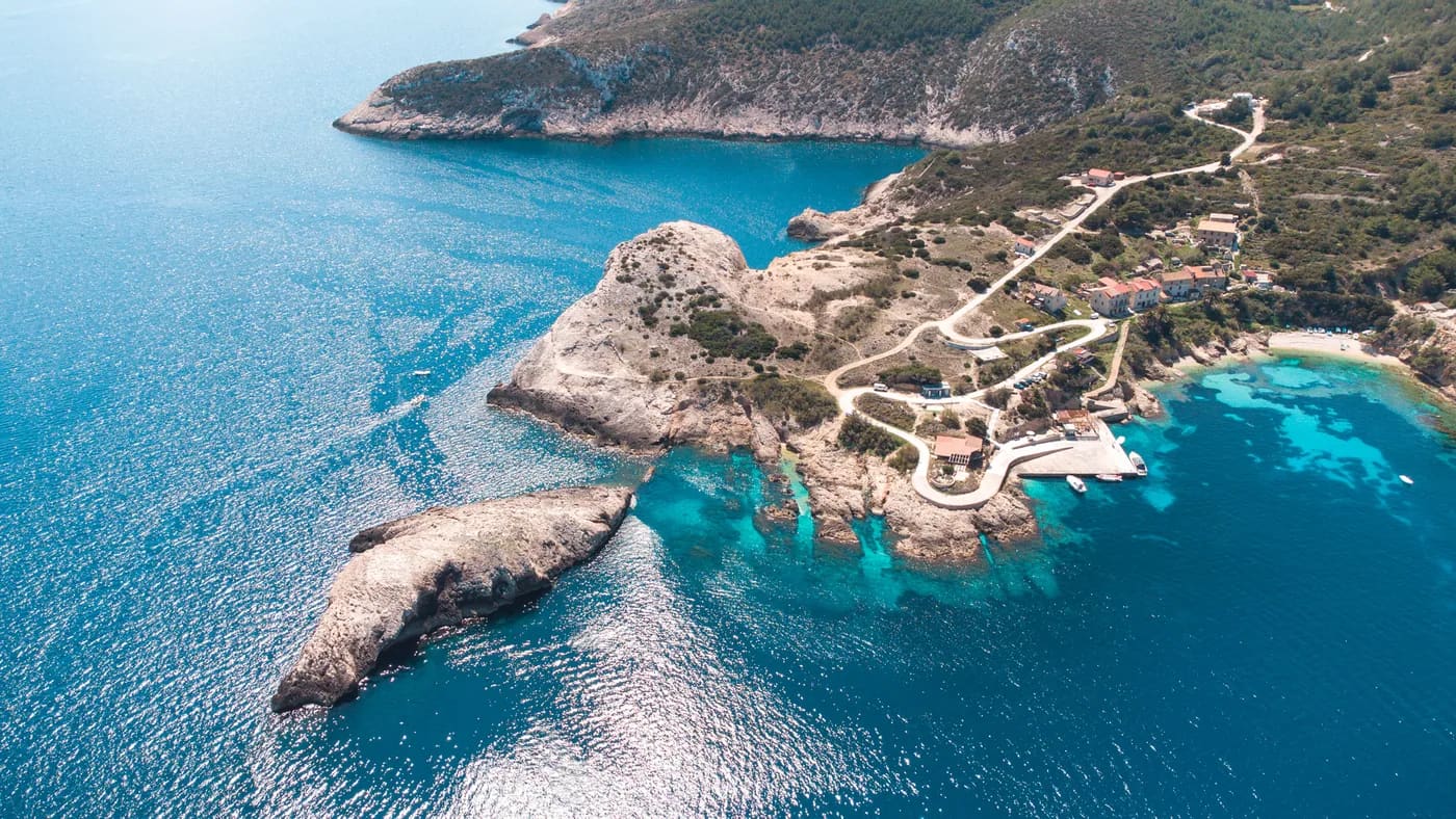 Aerial view of a rocky island and turquoise bay in the Vis archipelago