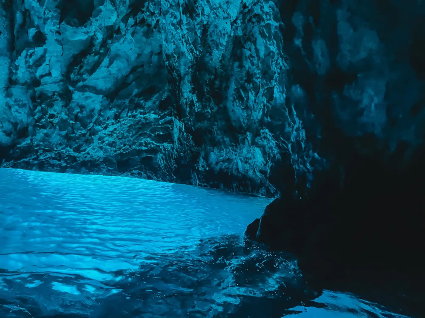 The Blue Cave's electric-blue light from a small boat
