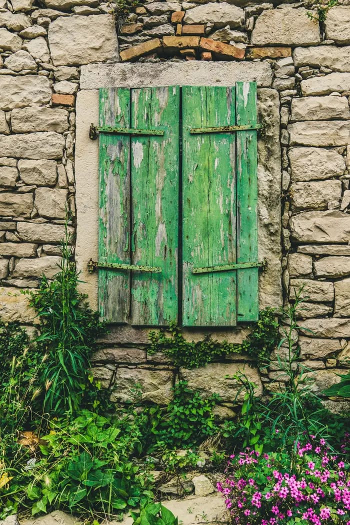 Weathered green shutters on a Dalmatian stone house in Trogir