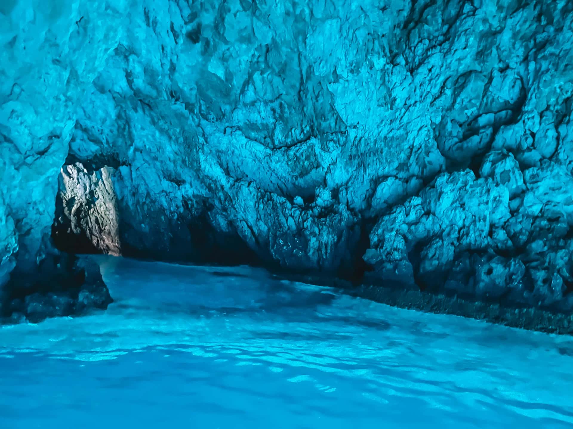 Inside the Blue Cave — electric-blue water and the cave's entrance